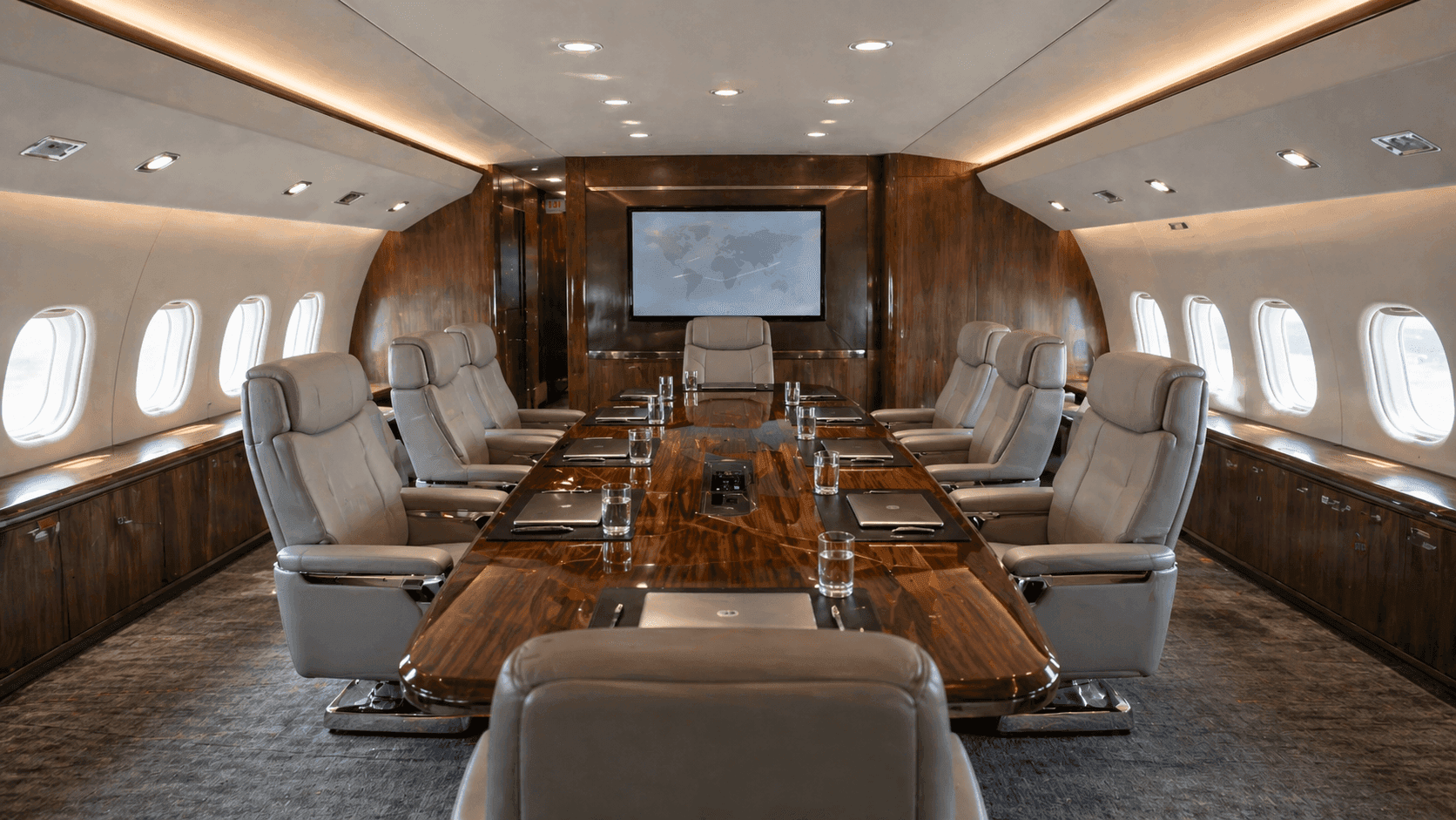 VIP airliner (bizliner) interior configured as a luxury boardroom, featuring a large conference table, leather seating, and premium finishes for executive meetings in flight.