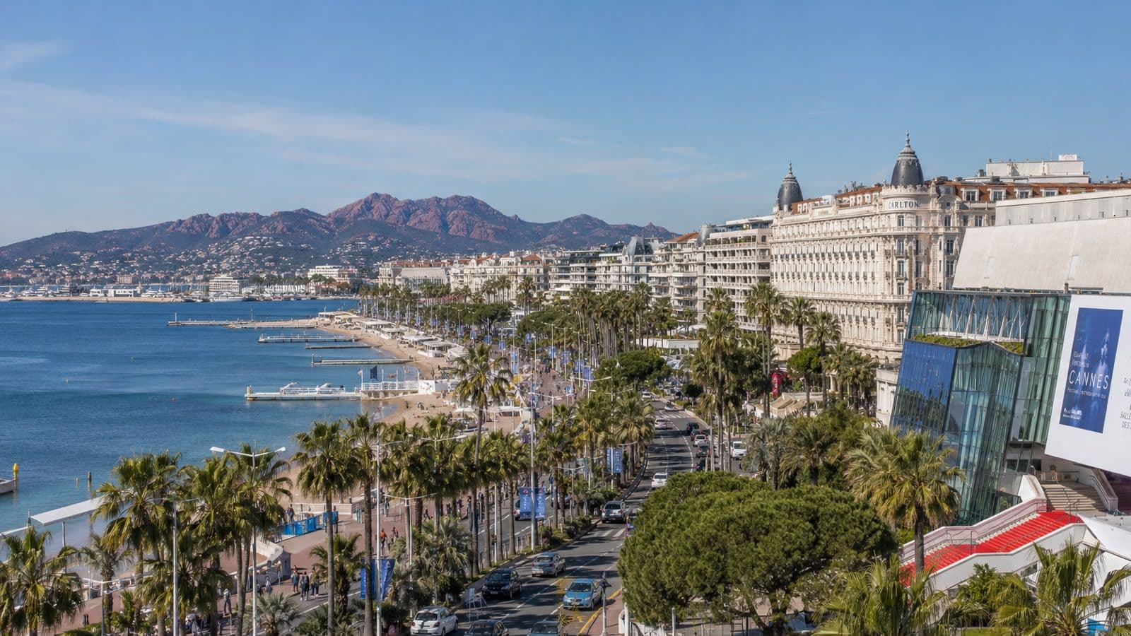 Panoramic view of Cannes’ La Croisette waterfront, luxury hotels, palm-lined boulevard, and Mediterranean coastline.