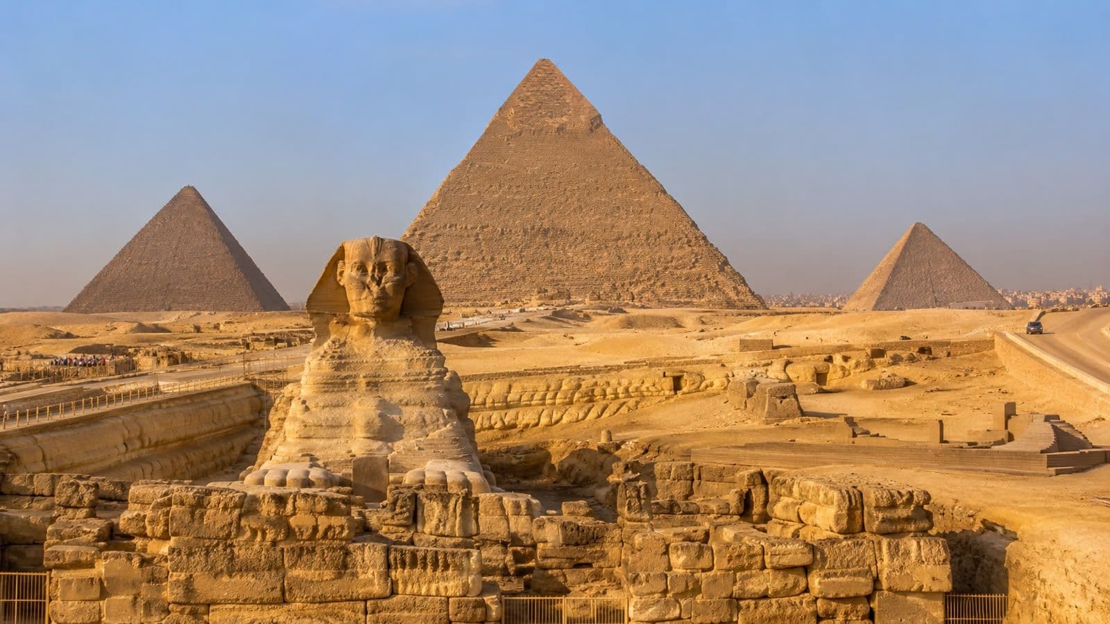 Panoramic view of the Great Sphinx and the Pyramids of Giza, showcasing Cairo’s iconic ancient monuments under a clear desert sky.