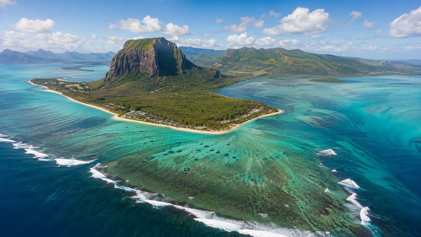 Aerial view of Mauritius island with turquoise lagoons, coral reefs, beaches, and lush mountains