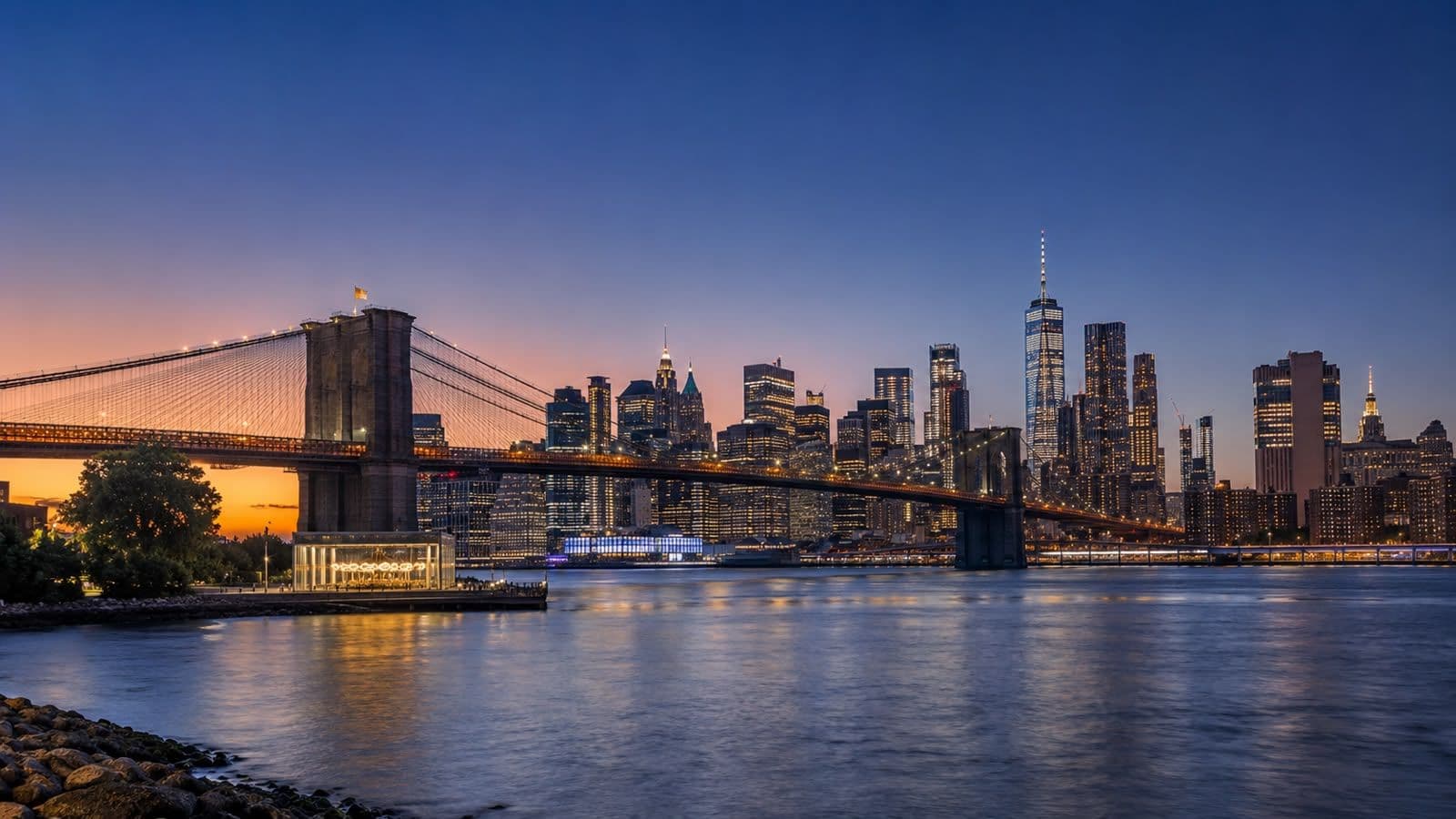 Panoramic view of the Brooklyn Bridge and the Manhattan skyline at sunset in New York City.