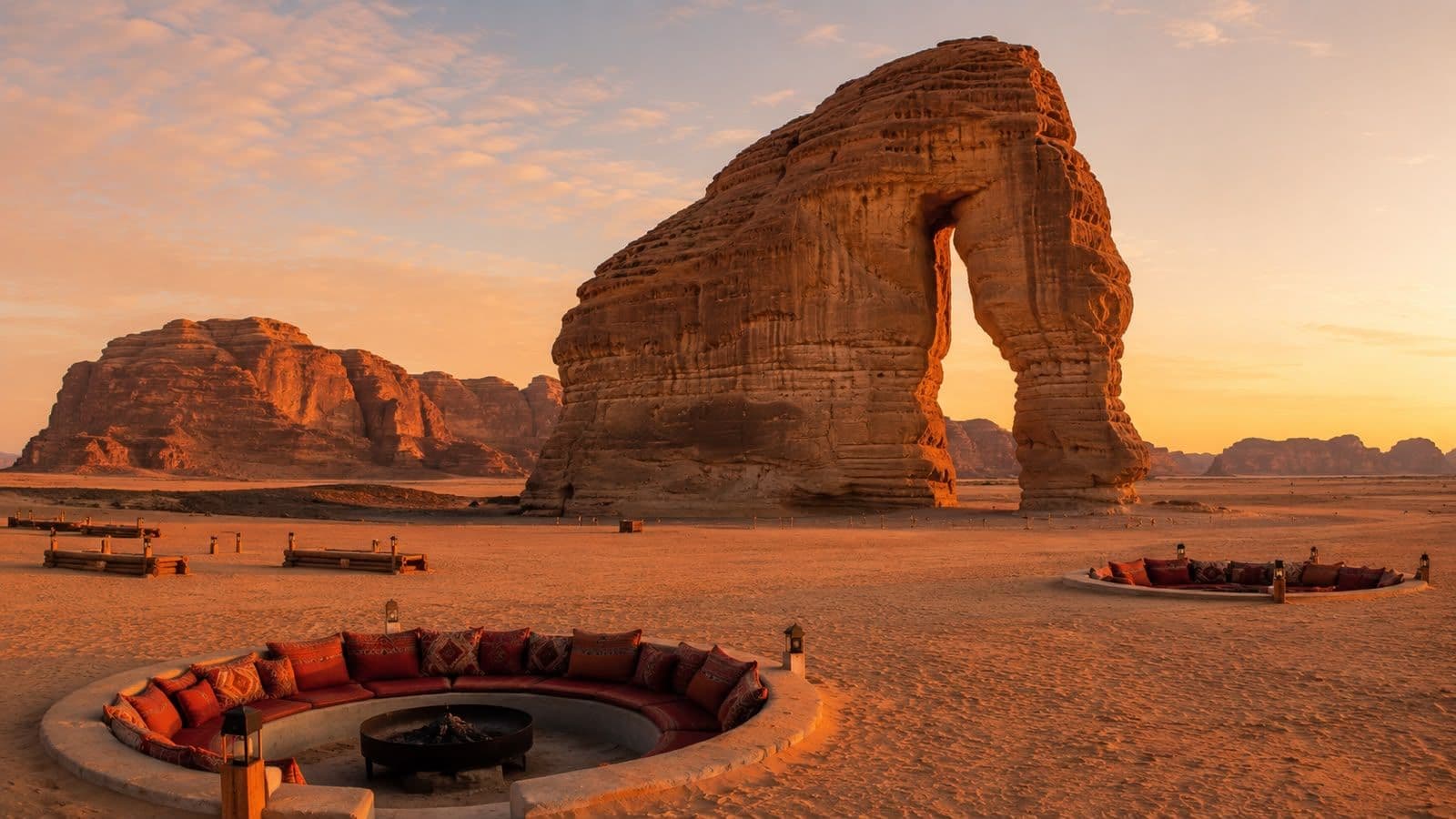 AlUla’s iconic Elephant Rock at sunset, surrounded by dramatic desert landscapes and luxury desert camp seating.