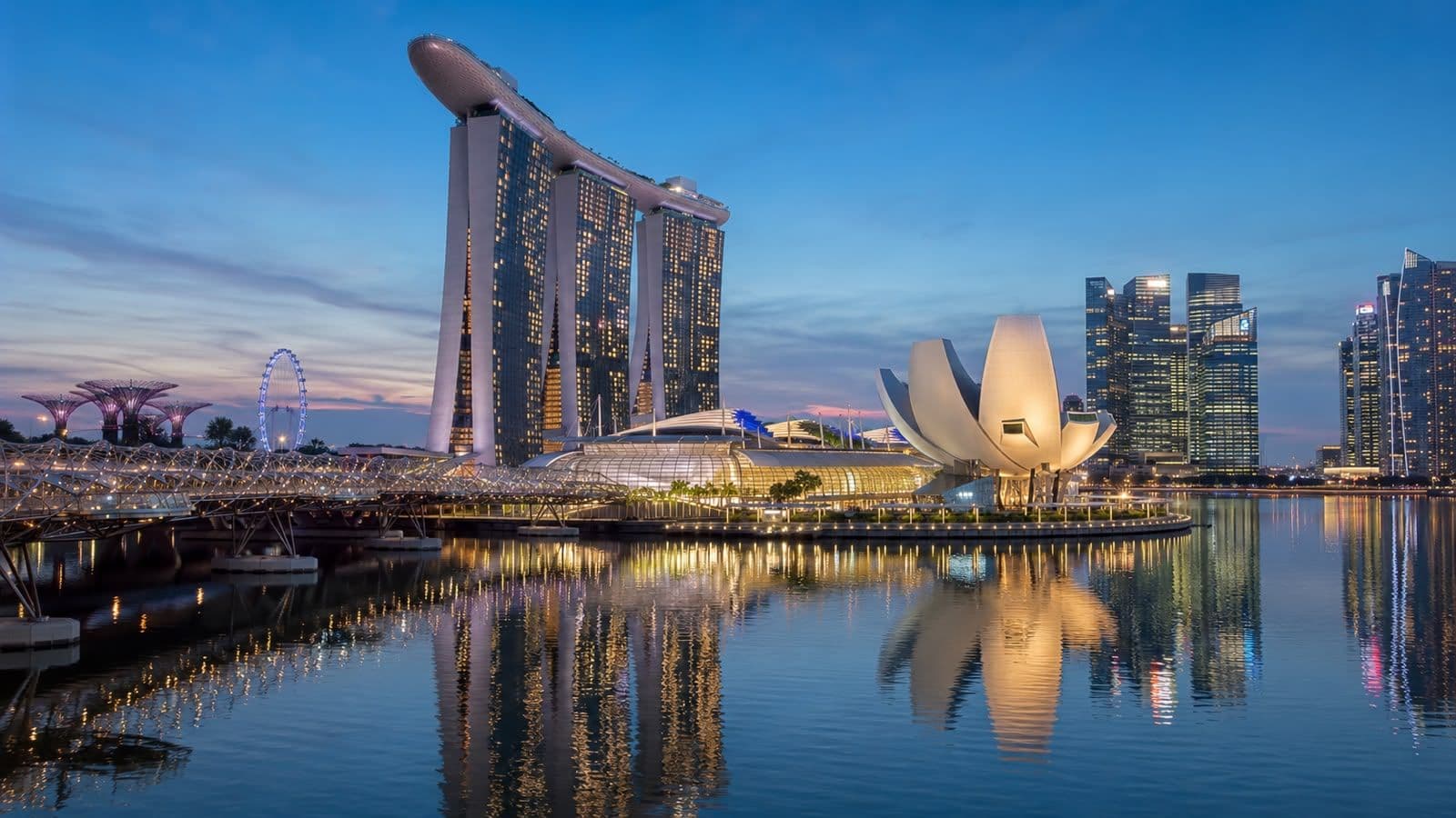 Singapore skyline at dusk featuring Marina Bay Sands, the ArtScience Museum, and waterfront reflections